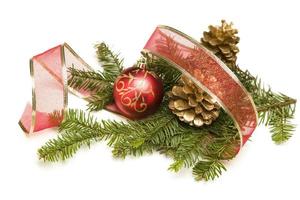 adornos navideños, piñas, cinta roja y ramas de pino en blanco foto