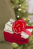 Woman Wearing Mittens Holding Stacks of Money with Red Ribbon photo