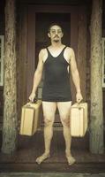 Gentleman Dressed in 1920's Era Swimsuit Holding Suitcases on Porch photo