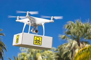 Unmanned Aircraft System Drone Carrying Package With Poison Symbol Label Over Tropical Terrain. photo