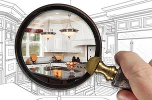 Hand Holding Magnifying Glass Revealing Finished Kitchen Build Over Drawing photo