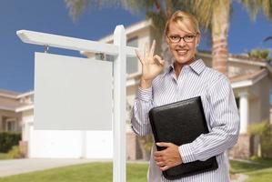 Real Estate Agent in Front of Blank Sign and House photo