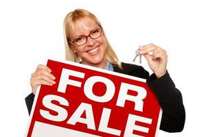 Attractive Blonde Holding Keys and For Sale Sign photo