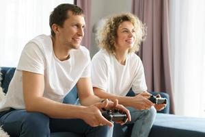 una pareja con gamepads está jugando una consola de videojuegos