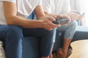 una pareja con gamepads está jugando una consola de videojuegos foto