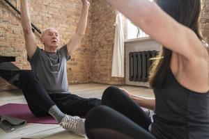 dos personas mayores durante el entrenamiento de fitness o yoga en casa foto