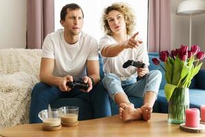 Couple with a gamepads are playing video game console photo