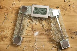 Cracked glass weighing scale on the floor photo