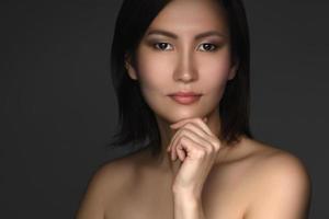 Portrait of young and beautiful asian woman on gray background photo