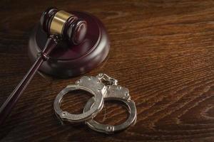 Gavel and Pair of Handcuffs on Table photo