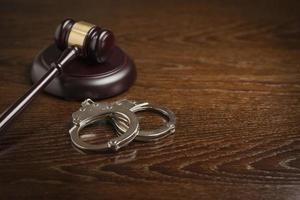 Gavel and Pair of Handcuffs on Table photo