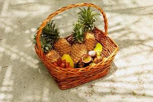 Basket full of fresh and different tropical fruits photo
