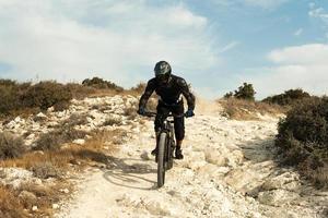 Rider fully equipped with protective gear during downhill ride on his bicycle photo
