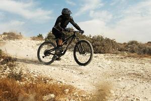 Rider fully equipped with protective gear during downhill ride on his bicycle photo