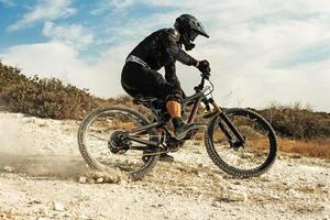 Rider fully equipped with protective gear during downhill ride on his bicycle photo