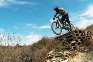 MTB bike rider jumping during downhill ride on his bicycle in mountains photo