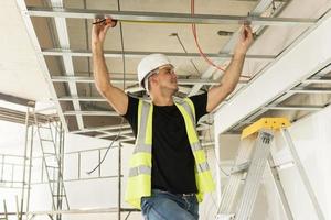 Worker with a measure tape on a construction site photo