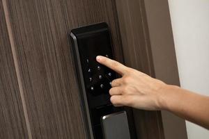 Hand and digital smart code lock into the modern apartment photo