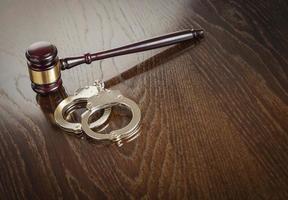 Gavel and Pair of Handcuffs on Table photo