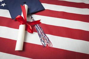 Graduation Cap and Diploma Resting on American Flag photo