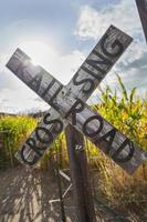 Señal de cruce de carretera de ferrocarril de país antiguo cerca de un campo de maíz foto