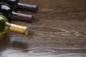 Various Wine Bottles on Reflective Wood Surface Abstract photo