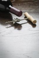 Abstract Wine Bottle and Corkscrew on Reflective Wood Surface photo