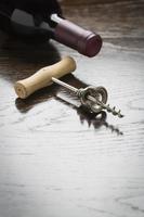 Abstract Wine Bottle and Corkscrew on Reflective Wood Surface photo