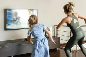 Family dancing with modern video game console at home photo