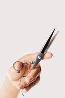 Female hand with a hair cutting shears photo