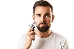 un apuesto hombre barbudo está usando una recortadora eléctrica foto