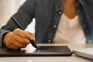 Female hand with pen-like stylus and graphic tablet photo