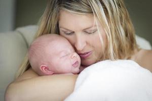 hermosa joven madre sosteniendo a su preciosa niña recién nacida foto