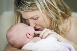 hermosa joven madre sosteniendo a su preciosa niña recién nacida foto