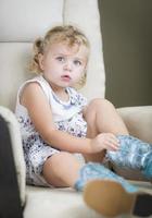Blonde Haired Blue Eyed Little Girl Putting on Cowboy Boots photo