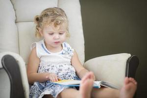 Blonde Haired Blue Eyed Little Girl Reading Her Book photo