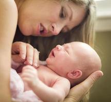 hermosa joven madre sosteniendo a su preciosa niña recién nacida foto