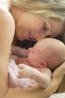 Young Beautiful Mother Holding Her Precious Newborn Baby Girl photo