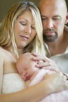 hermosa joven pareja sosteniendo a su bebé recién nacido foto