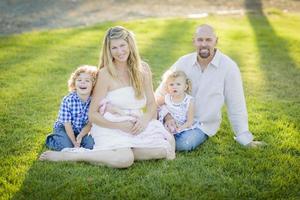 Beautiful Young Family Portrait Outside on Grass photo