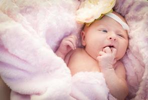 Beautiful Newborn Baby Girl Laying in Soft Blanket photo