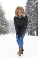 mujer joven y alegre que disfruta caminando durante el hermoso día de invierno foto