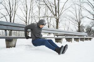 hombre atlético haciendo flexiones durante su entrenamiento calisténico de invierno foto