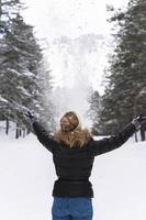 Woman throwing snow into the air during cold winter day photo