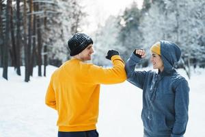 Two joggers greeting each other with a elbow bump gesture during winter workout