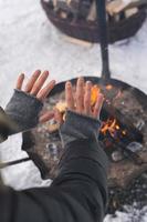Woman warming up her hands by the fire pit photo