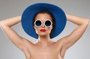 Beautiful woman wearing blue hat and sunglasses is ready for vacation photo