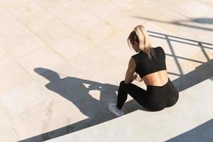 Young athletic woman and her shadow during summer workout photo