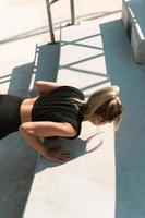 Athletic woman is doing push-ups during summer calisthenic workout photo