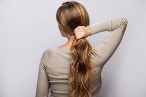 mujer joven mostrando su hermoso cabello después de teñir y peinar foto